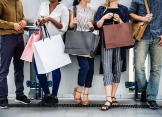 Top 10 Fashion Brand Famous Regular Discounts for Shoppers Shoppers carrying bags past a store sale sign