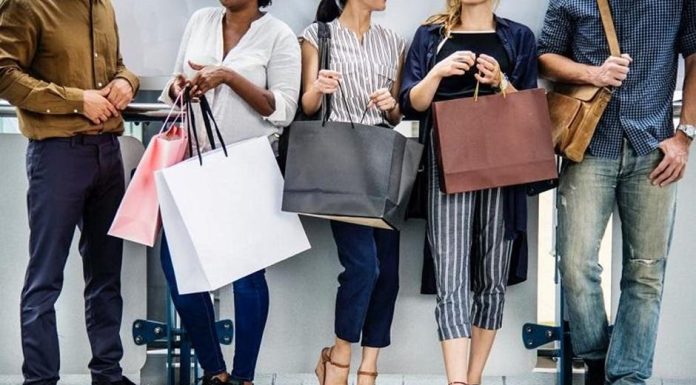 Top 10 Fashion Brand Famous Regular Discounts for Shoppers Shoppers carrying bags past a store sale sign
